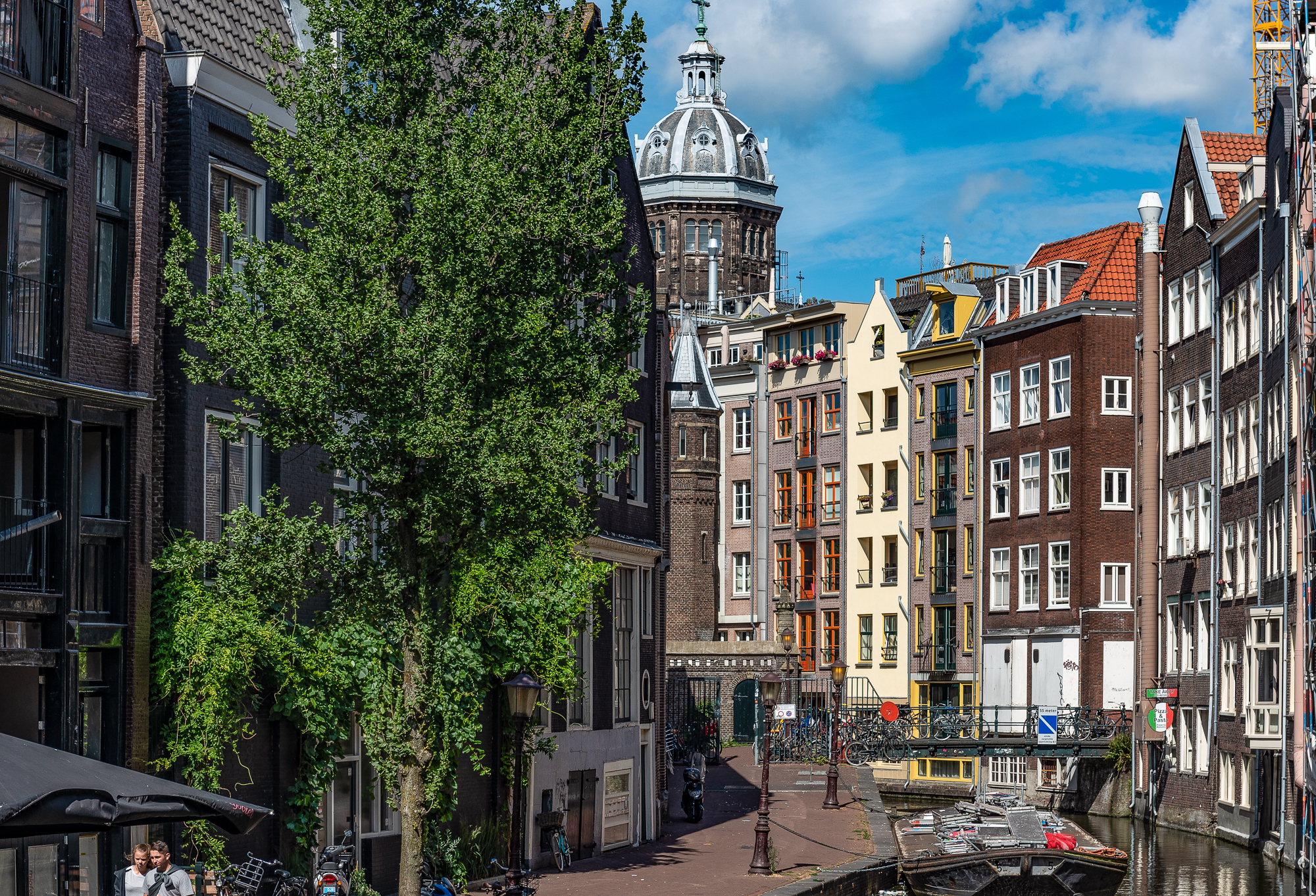 Il  canale Oudezijds Voorburgwal, con la cupola della Basilica di San Nicola sullo sfondo
